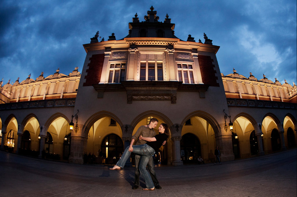 Fiance dipping his girl in frot of the Cloth Hall in  Cracow