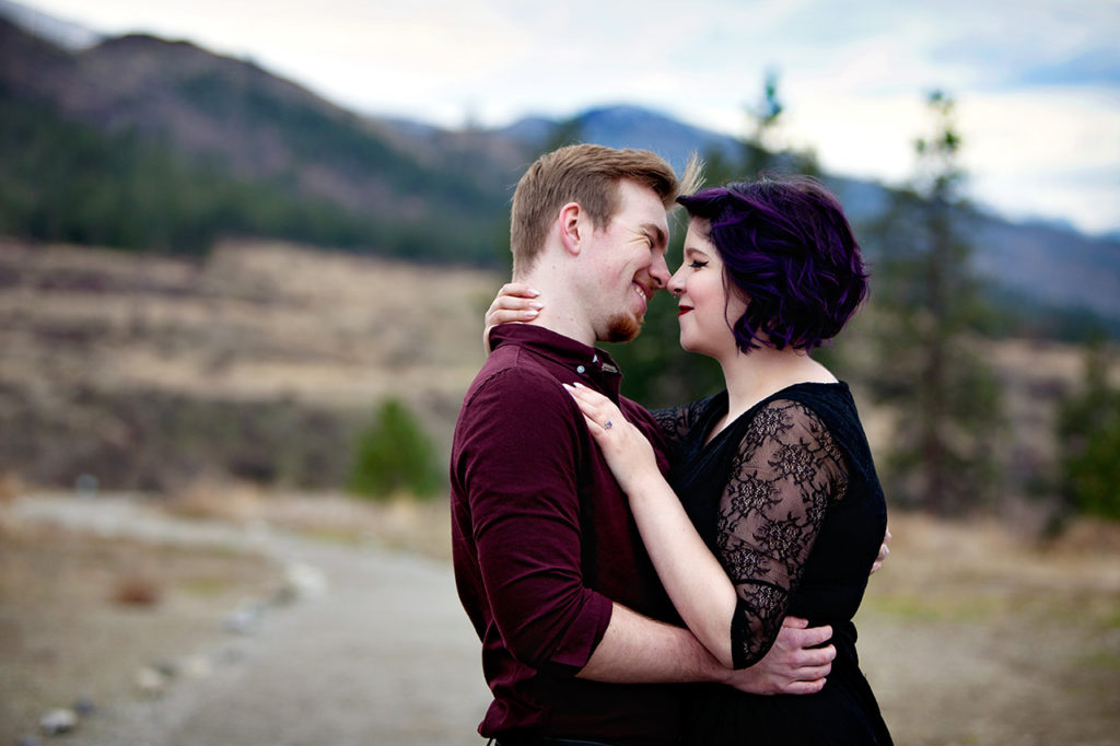 Couple Looking at each other with Kelowna Mountains in the Background